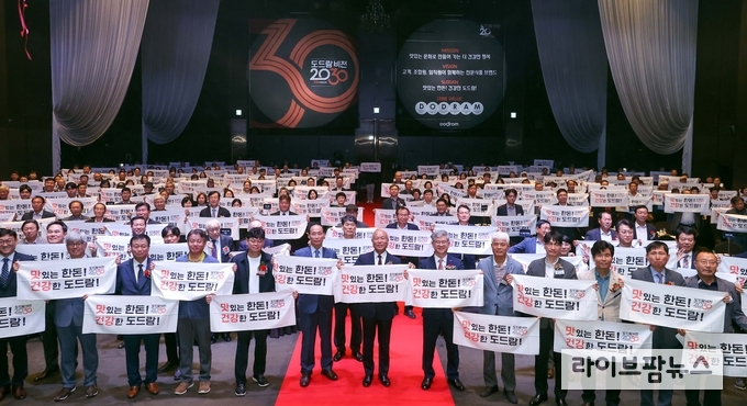 도드람 비전 2030 선포식에서 새로운 슬로건을 들고 있는 참석자 단체사진.
