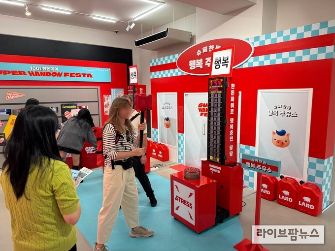 한돈에 풍부한 ‘트립토판(행복호르몬)’에 관한 정보를 ‘트립토판 해머 타격 게임’으로 체험 중인 외국인 방문객.